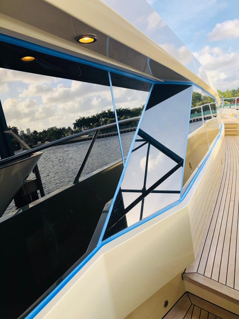 Modern yacht with reflective windows on water.