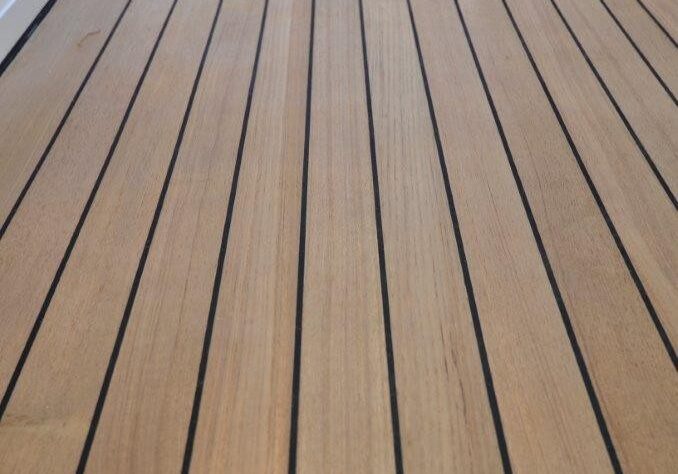Wooden boat deck with person in background.