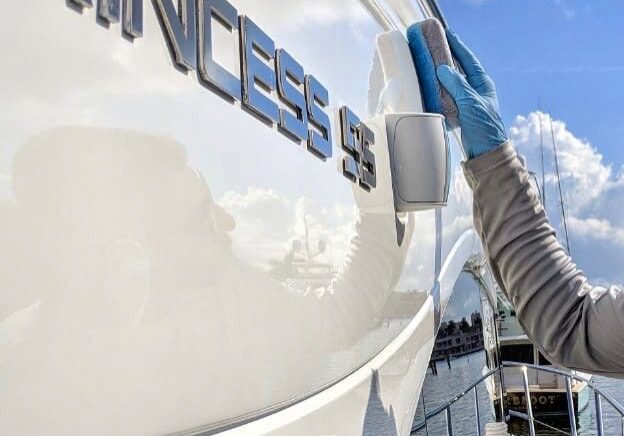Cleaning a yacht with polishing product.